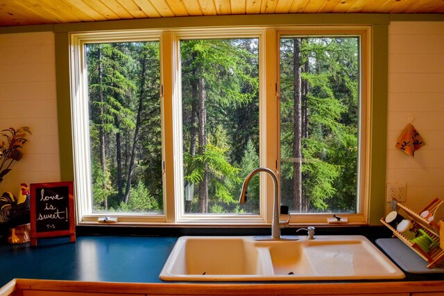 kitchen featuring light hardwood / wood-style flooring, wooden ceiling, white gas range oven, and wall chimney exhaust hood