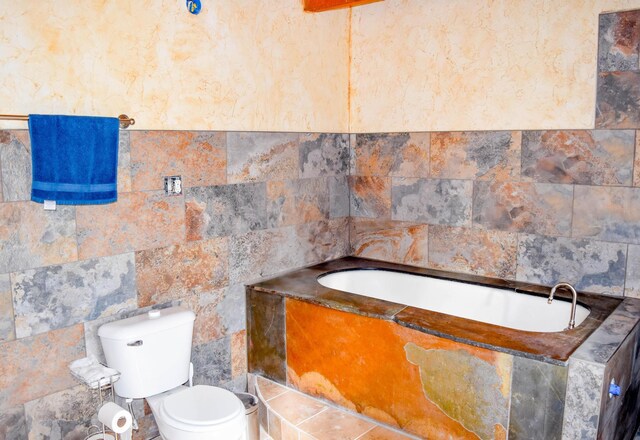 bathroom with a relaxing tiled tub