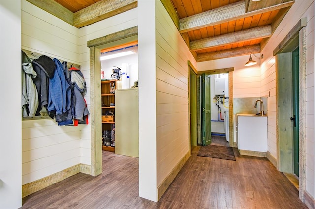 hall with wood ceiling, wood walls, wood-type flooring, and beamed ceiling