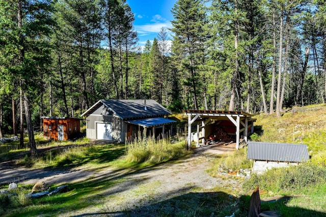 view of front of house featuring a garage and an outbuilding