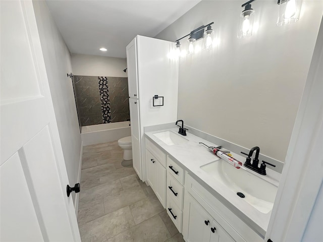 full bathroom with vanity, tiled shower / bath, and toilet