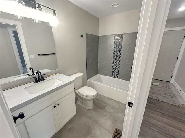 full bathroom with tiled shower / bath, vanity, toilet, and wood-type flooring