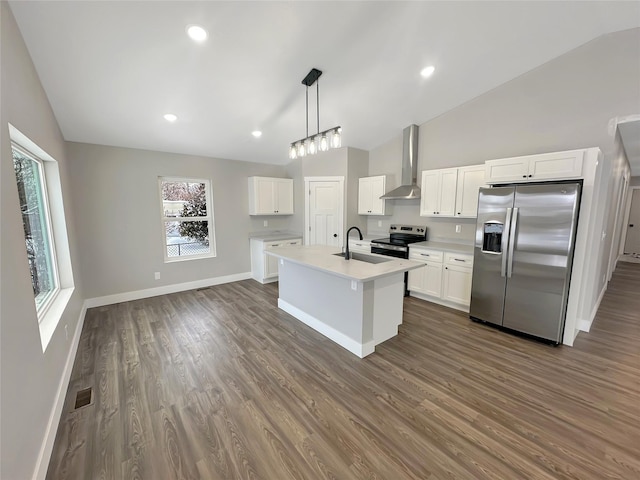 kitchen featuring appliances with stainless steel finishes, white cabinetry, sink, a center island with sink, and wall chimney exhaust hood