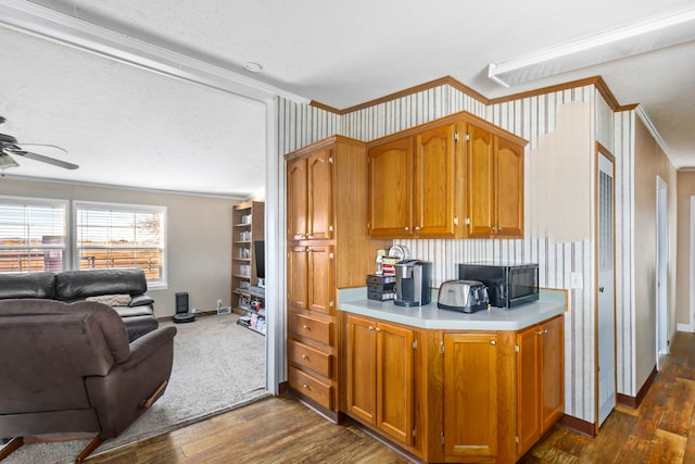 kitchen featuring dark wood-type flooring, ornamental molding, and a textured ceiling