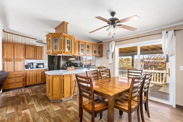 dining room featuring crown molding, ceiling fan, dark hardwood / wood-style flooring, and a textured ceiling