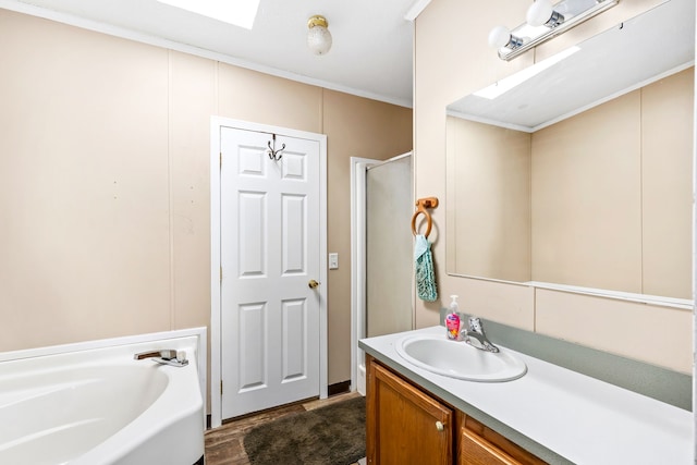 bathroom with plus walk in shower, ornamental molding, and vanity