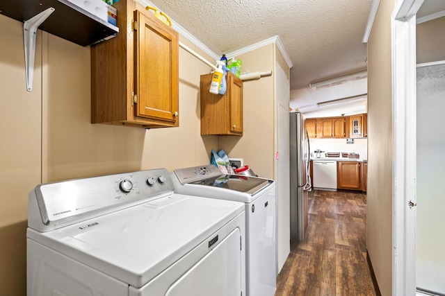 laundry area with dark wood-type flooring, crown molding, cabinets, separate washer and dryer, and a textured ceiling