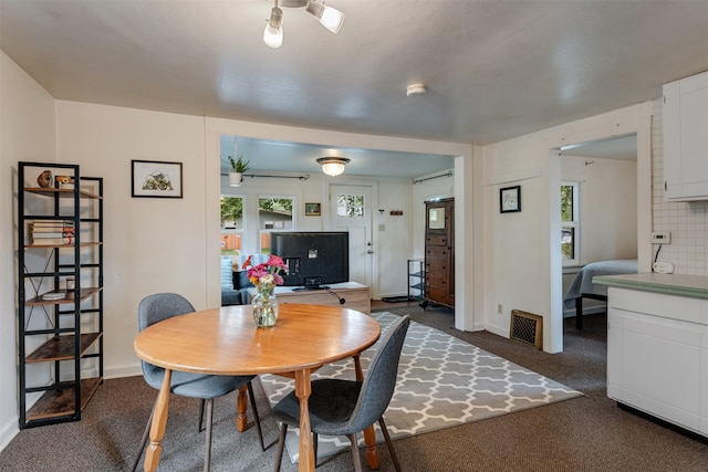 dining area featuring dark carpet