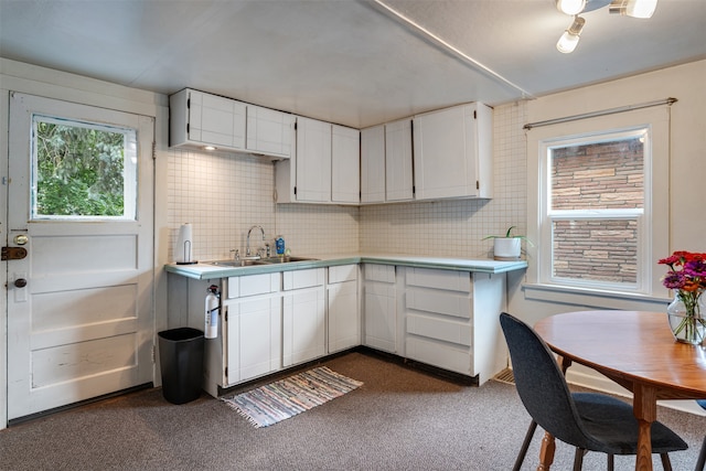 kitchen featuring white cabinetry, sink, and backsplash