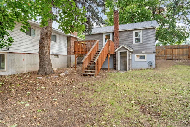 rear view of house featuring a deck and a yard