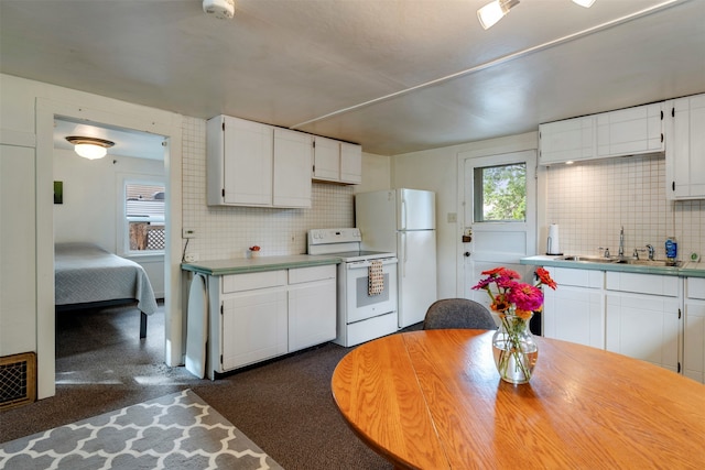 kitchen featuring sink, white appliances, white cabinetry, and backsplash