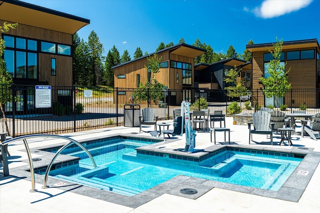 view of swimming pool with a hot tub and a patio area