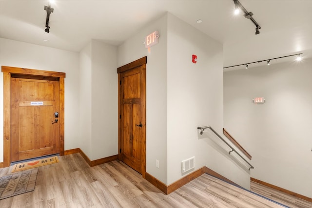 interior space featuring light wood-type flooring and rail lighting