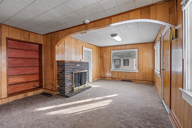 161 3rd Ave, Kalispell, MT 59901 - unfurnished living room with wooden walls, carpet, a fireplace, and built in features