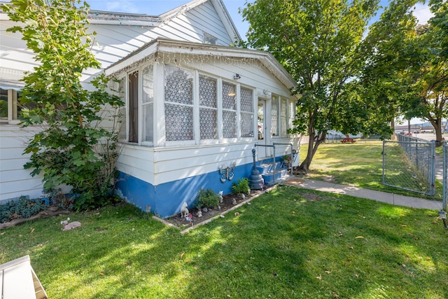 view of property exterior with a yard, a gate, fence, and entry steps