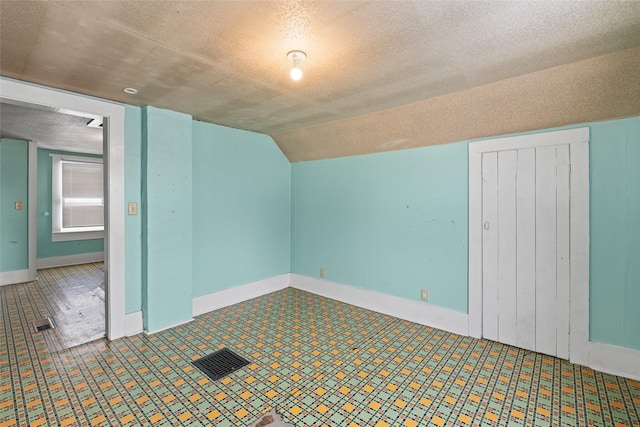 161 3rd Ave, Kalispell, MT 59901 - bonus room featuring a textured ceiling, lofted ceiling, and tile patterned floors