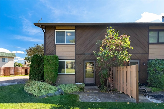 view of front of home featuring a front yard, fence, and a patio area