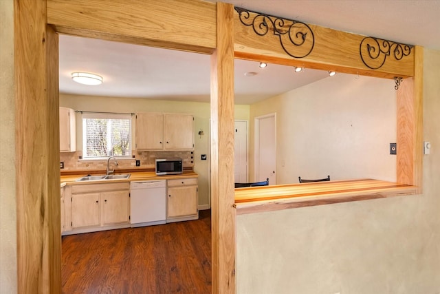 kitchen featuring a sink, tasteful backsplash, dishwasher, dark wood-style floors, and stainless steel microwave
