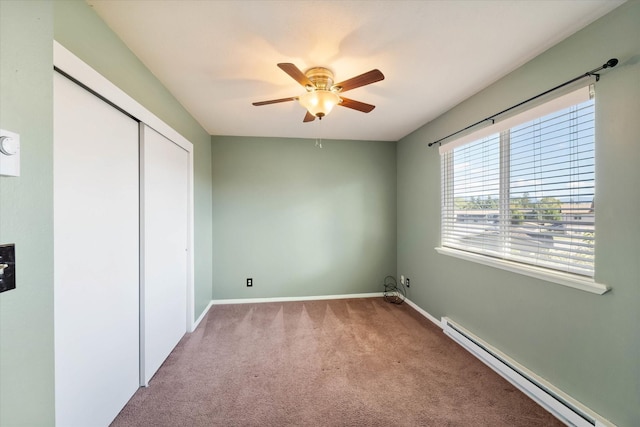 unfurnished bedroom with a closet, carpet, baseboards, a ceiling fan, and a baseboard heating unit