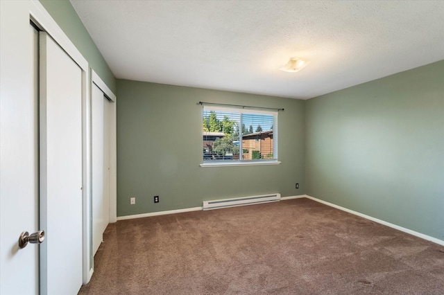 unfurnished bedroom with carpet floors, a textured ceiling, a baseboard radiator, baseboards, and two closets