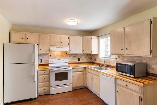 kitchen with white appliances, light brown cabinetry, under cabinet range hood, decorative backsplash, and a sink