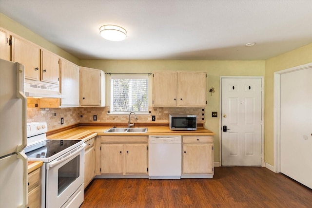 kitchen with light countertops, white appliances, light brown cabinets, under cabinet range hood, and a sink