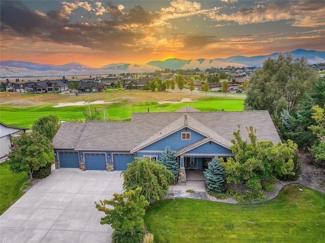 view of front of home featuring a yard, a garage, and a mountain view