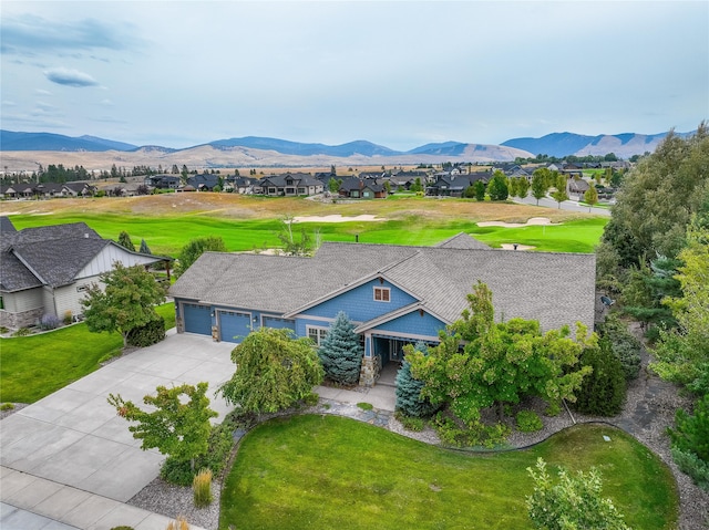 view of front facade featuring a mountain view, a front lawn, and a garage