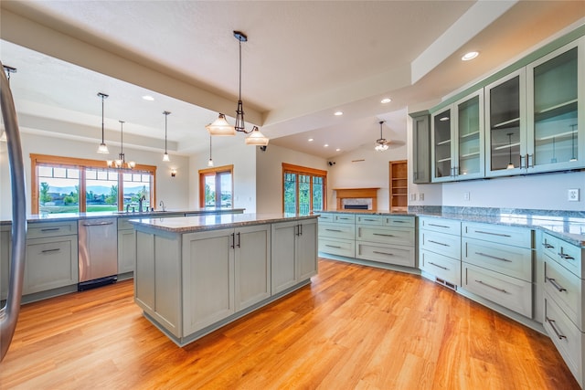 kitchen featuring dishwasher, decorative light fixtures, light hardwood / wood-style floors, and a center island