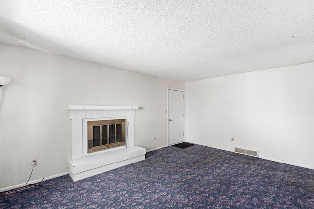 unfurnished living room with carpet flooring, a brick fireplace, baseboards, visible vents, and a textured ceiling