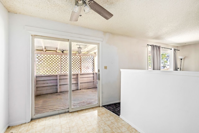 interior space with tile patterned floors, a textured ceiling, a ceiling fan, and baseboards