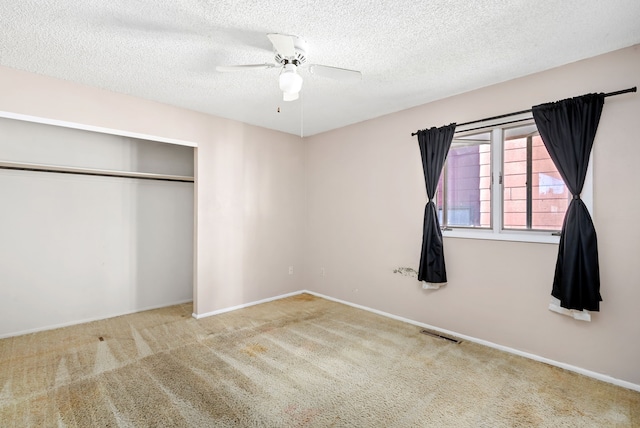 unfurnished bedroom featuring carpet floors, a textured ceiling, ceiling fan, and a closet