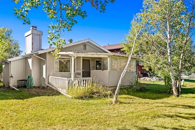view of front of home with a front yard and a chimney