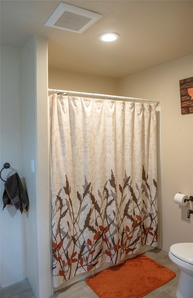 bathroom with curtained shower and toilet