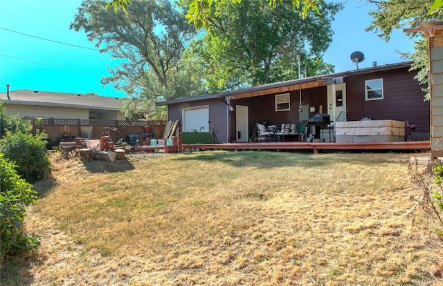 rear view of house with a deck and a yard