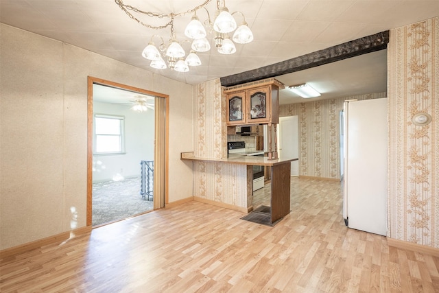 kitchen with wallpapered walls, electric stove, light wood-style floors, and freestanding refrigerator
