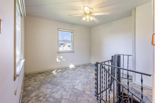 carpeted empty room with baseboards and ceiling fan
