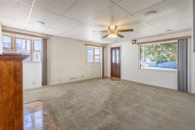 empty room featuring carpet, a drop ceiling, and ceiling fan