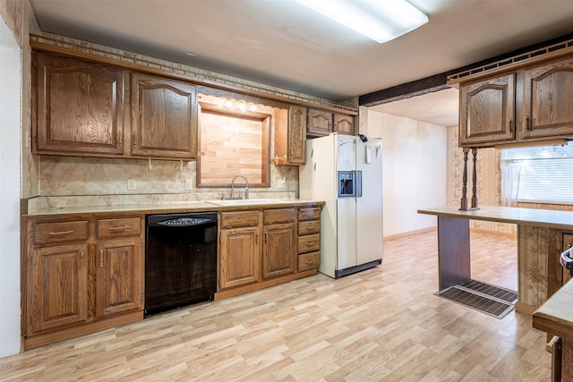kitchen featuring white fridge with ice dispenser, dishwasher, a sink, light wood-type flooring, and decorative backsplash
