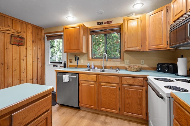 114 Cedar Way Unit 114, Whitefish, MT 59937 - kitchen featuring stainless steel dishwasher, white range with electric cooktop, light countertops, light wood finished floors, and wood walls