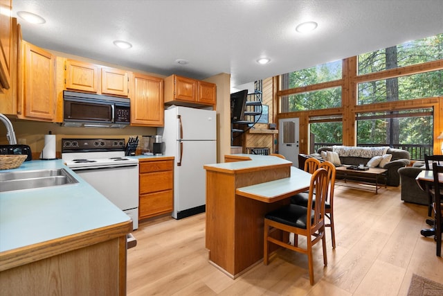 114 Cedar Way Unit 114, Whitefish, MT 59937 - kitchen featuring white appliances, light countertops, a kitchen island, light wood-style flooring, and recessed lighting
