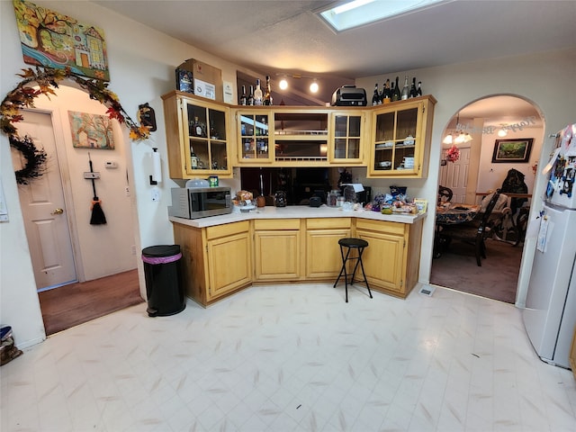 kitchen featuring white refrigerator and a textured ceiling