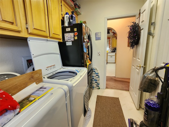 washroom with washer and clothes dryer and cabinets