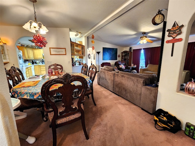 carpeted dining area featuring ceiling fan with notable chandelier