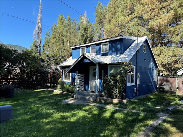 view of front of home with fence, a front yard, and metal roof