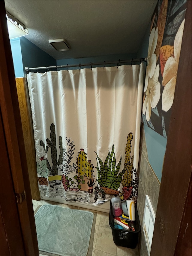 bathroom featuring walk in shower and a textured ceiling