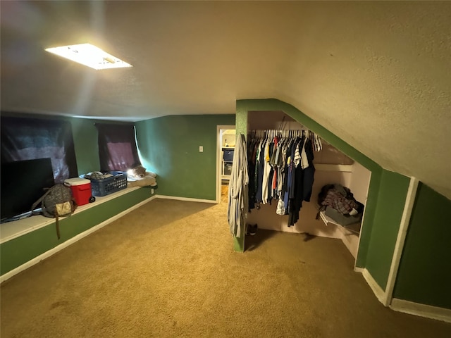 interior space featuring vaulted ceiling, a textured ceiling, and carpet flooring