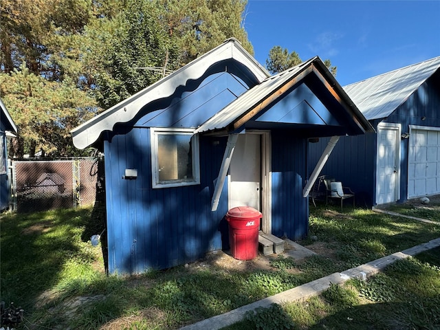 view of front facade featuring fence, an outbuilding, and a garage