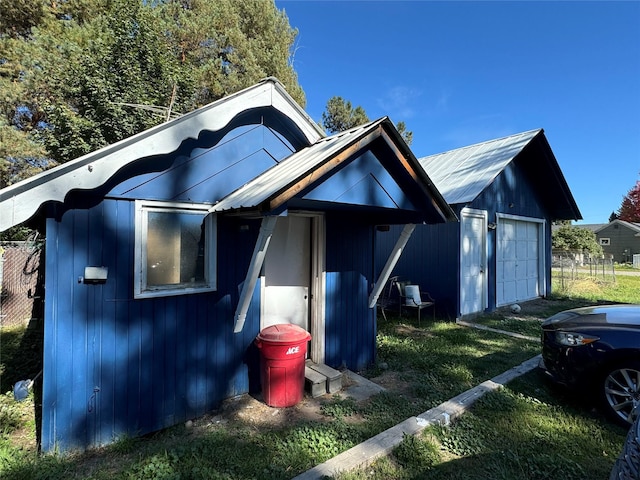 view of front of property with an outdoor structure, a garage, and metal roof