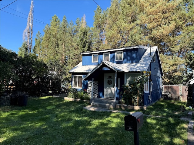 view of front of house featuring metal roof and a front yard